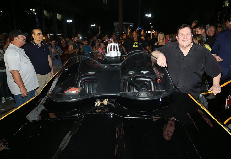 “Batman” TV series star Burt Ward poses with the original Batmobile at a tribute ceremony for Adam West at City Hall in Los Angeles on June 15, 2017. (Jesse Grant, Getty Images for DC Entertainment)